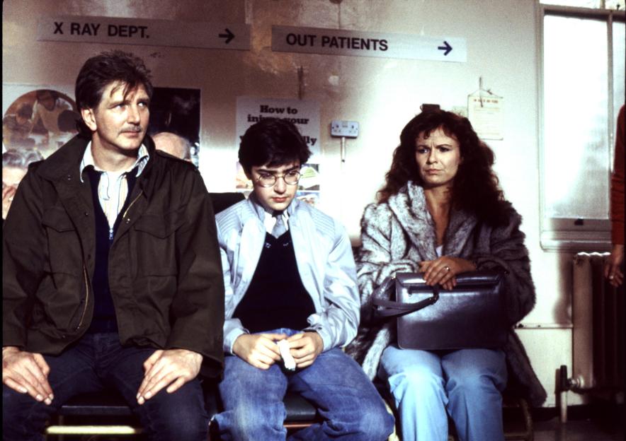 Stephen Moore, Gian Sammarco, and Julie Walters in a waiting room from the TV series "The Secret Diary of Adrian Mole".