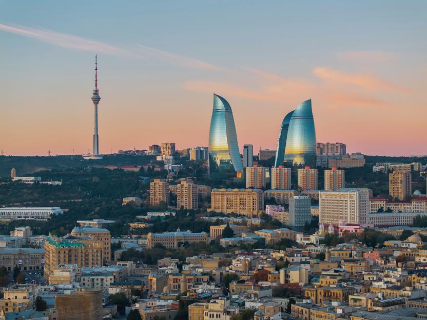 Baku's iconic skyline at dusk, featuring the Flame Towers and TV Tower overlooking the historic city center.
