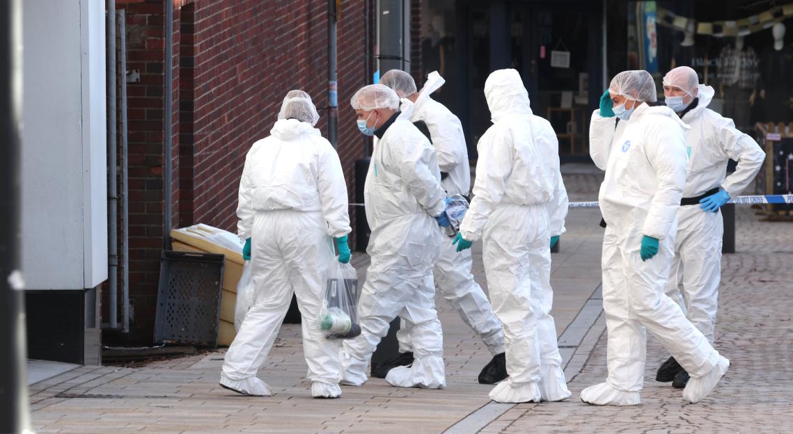 Forensic officers in white suits and masks at a crime scene on Railway Street, Altrincham.