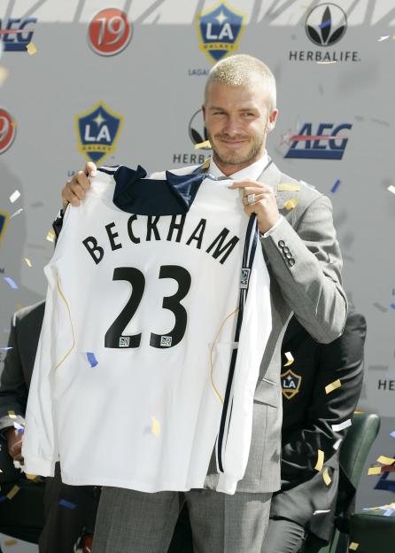 David Beckham holds up his Los Angeles Galaxy jersey with the number 23 and his name on the back.