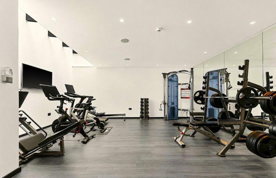 Home gym with exercise bikes, a rowing machine, and weightlifting equipment.