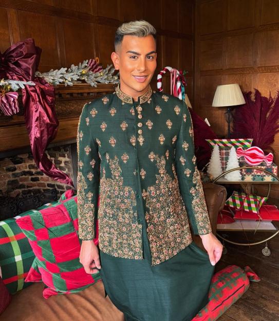 Junaid Ahmed in a traditional green embroidered jacket and trousers.