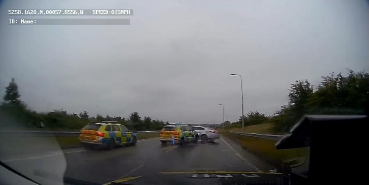 Dashcam footage of police vehicles cornering a car on a highway.