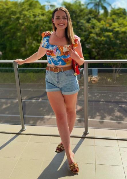 Charlotte Rutherford smiling on a balcony.