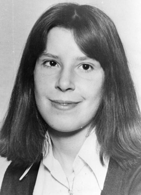 Black and white close-up of a young woman with long dark hair, smiling slightly.