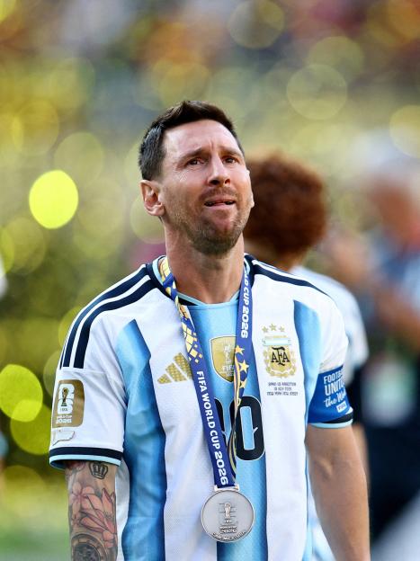 Lionel Messi, wearing an Argentina jersey and a silver medal from the FIFA World Cup 2026, looks dejected.