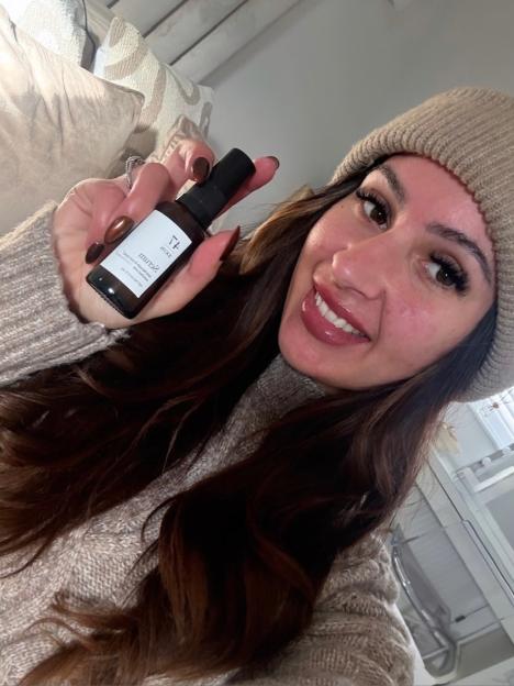 Emily Howdle holding up a bottle of 47Skin serum.
