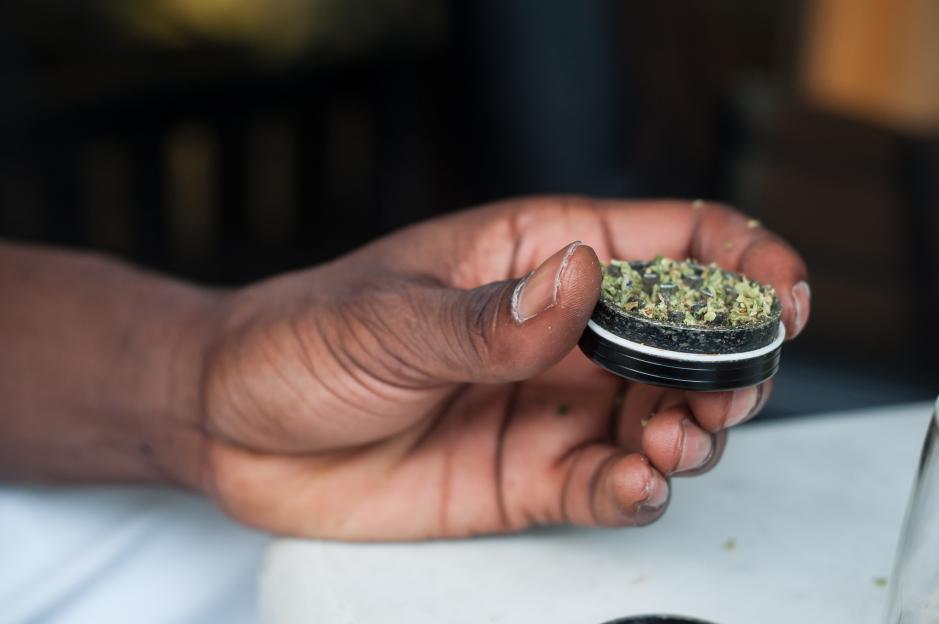 african man rolling a joint of cannabis in outdoor