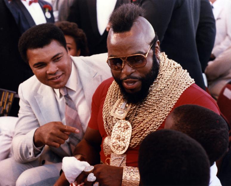 Muhammad Ali and Mr. T interacting at a boxing event.