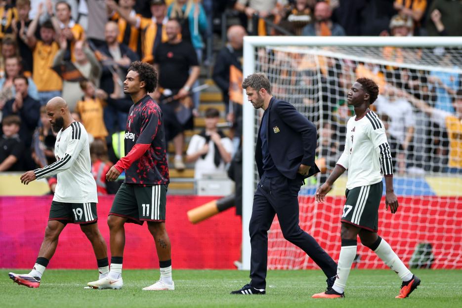Michael Carrick walking off the field, dejected after Manchester United's 2-0 defeat against Hull City, with other players walking next to him.
