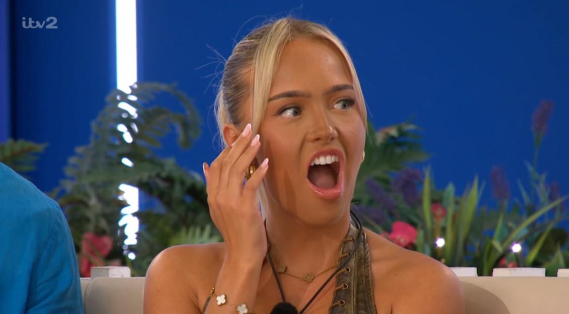 A woman with blonde hair looking shocked with her mouth open.