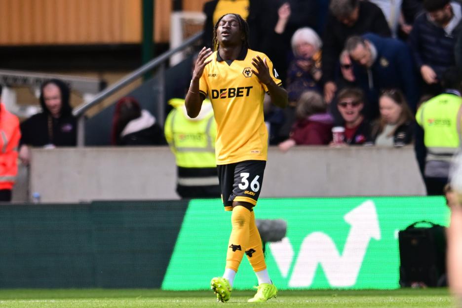 A Wolverhampton Wanderers player in a yellow and black uniform with number 36 on his shorts gestures on the field.