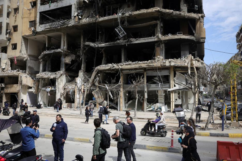Members of the media work near damaged buildings amid a 10-day ceasefire between Lebanon and Israel, in Beirut