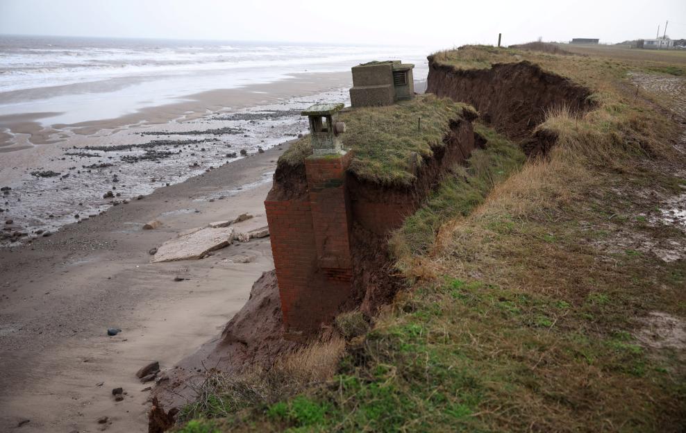 A decommissioned Cold War era nuclear observation post partially falling down an eroded cliff edge caused by coastal erosion at the village of Tunstall near Hull