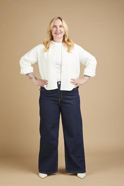 Annikki Sommerville modeling dark blue wide-leg jeans with a white shirt and white heels.