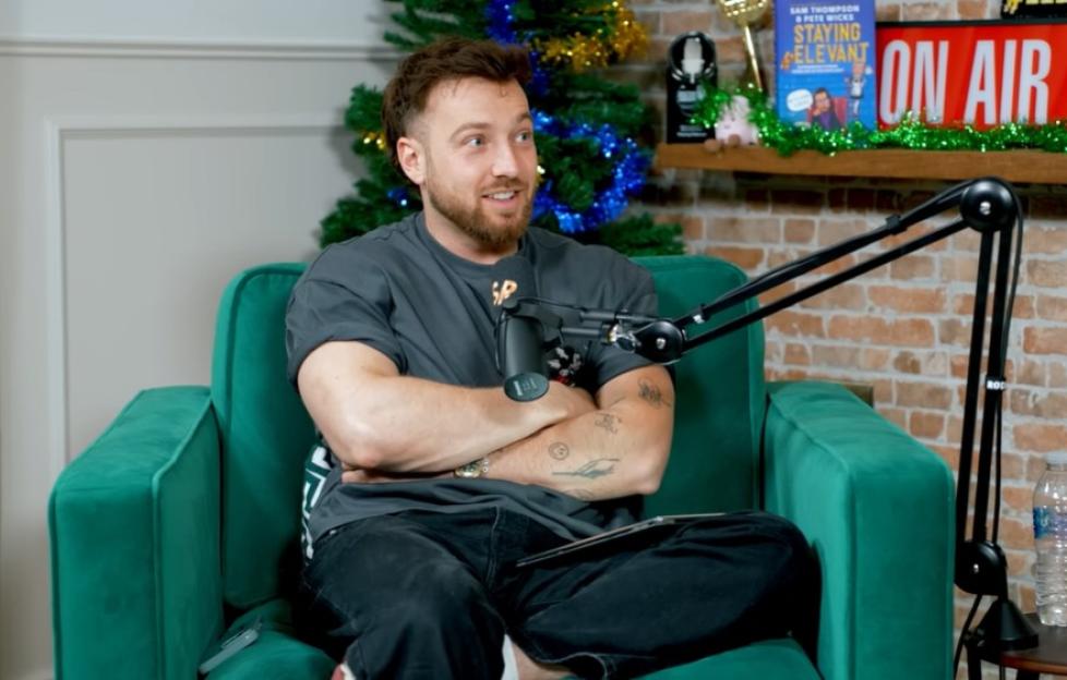 Sam Thompson sitting in a green chair with a microphone in front of him on the Staying Relevant podcast.