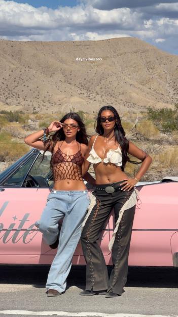 Samie Elishi and Sophie Piper posing in front of a pink car at Coachella.