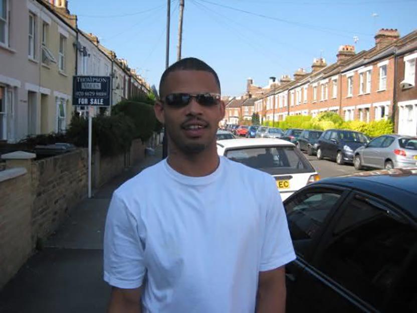 Leon Sosseh on a street lined with houses and cars.