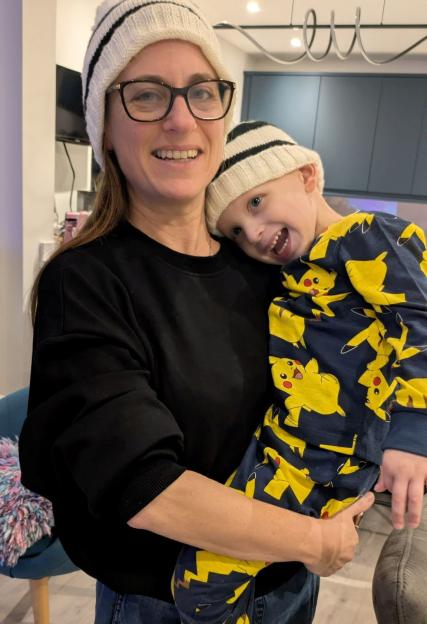 Raffi Starkowitz with his mother Nicky, both wearing striped knit hats.