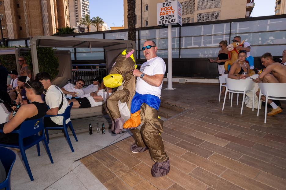 Man in an inflatable horse costume watches Cheltenham Festival horse races at the Marina Resort hotel in Benidorm, Spain.