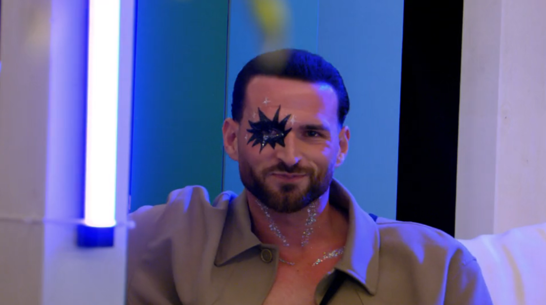 Ronnie Vint with a black star painted around his right eye and glitter on his chest.