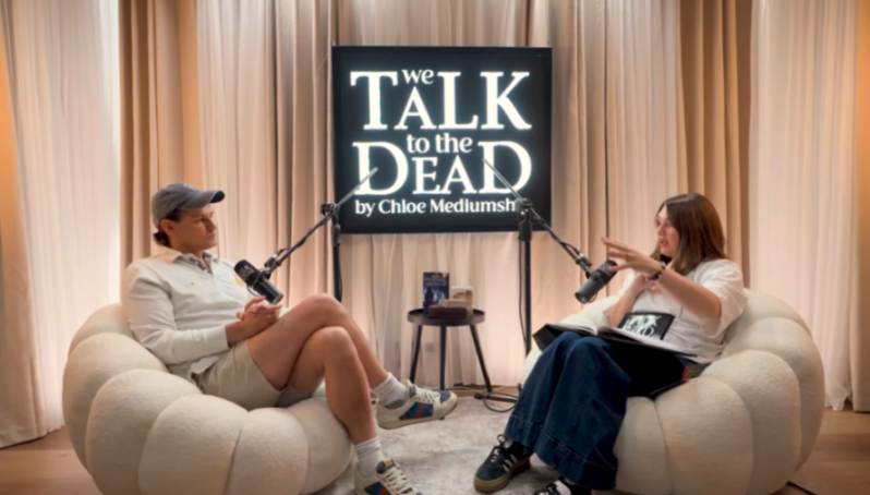 Two people sitting in comfortable chairs, podcasting with microphones.