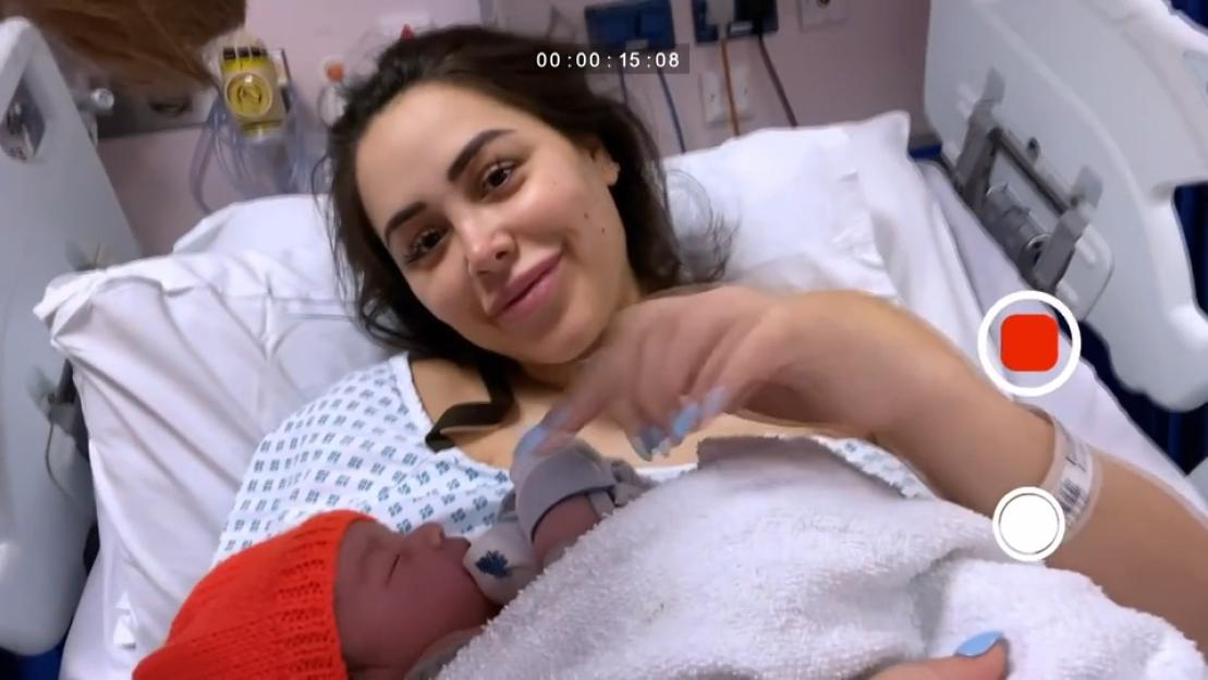 Marnie Simpson in a hospital bed holding her newborn baby.