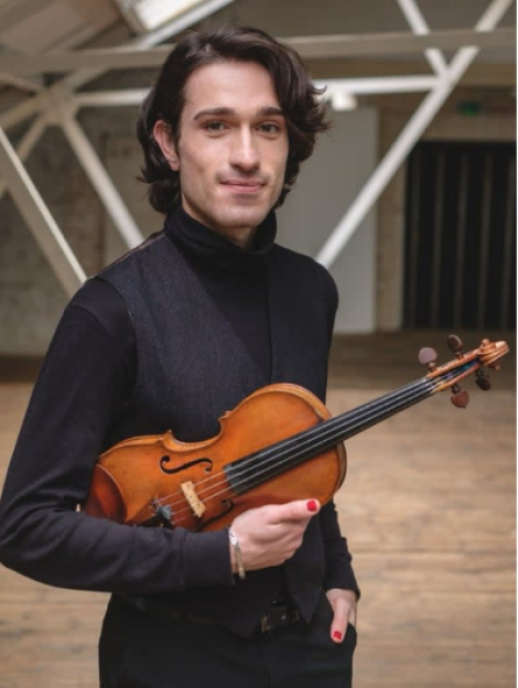 Ahmed Sami Madour holding a violin.