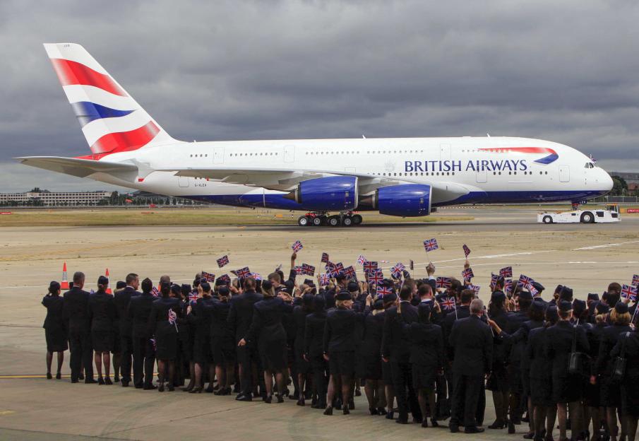 British Airways A380 at Heathrow Airport with staff waving Union Jack flags.