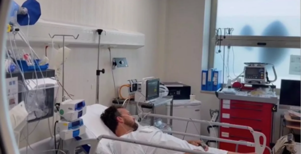 Jon Harman, husband of Jasmine Harman, in a hospital bed with medical equipment.