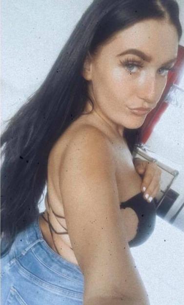 Amy McNamara wearing a black top and blue jeans.