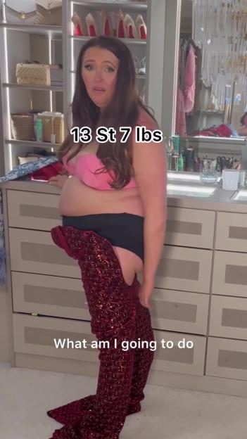 Charlotte Dawson wearing a bra and underwear while attempting to pull on a pair of red sequined pants with the text "13 St 7 lbs" and "What am I going to do".