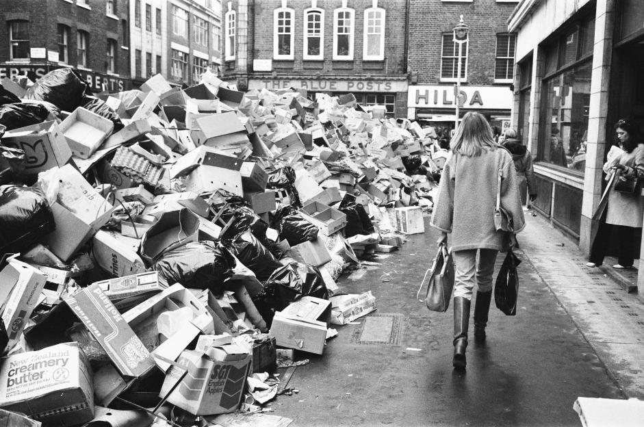 Rubbish, including boxes and black bags, piled high on a London street due to industrial action.