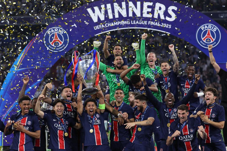 Marquinhos lifts the Champions League trophy with his Paris Saint-Germain teammates as golden confetti falls around them.