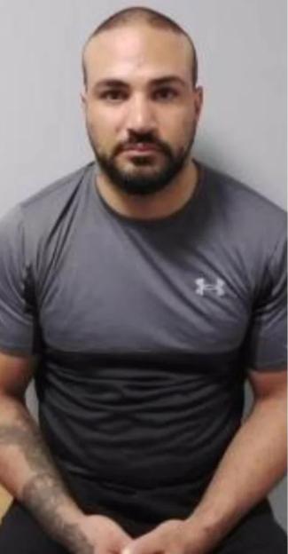 Deniz Mehmet, a man with a beard and receding hairline, wearing a gray shirt, in a mugshot.