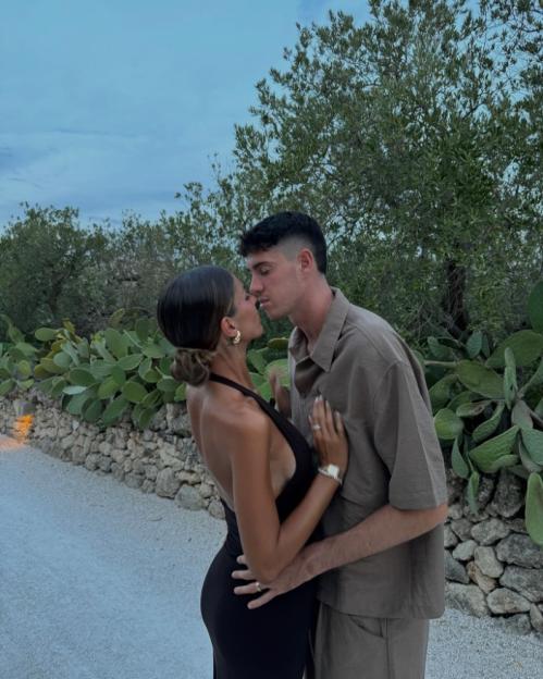 A couple embracing and kissing outdoors.