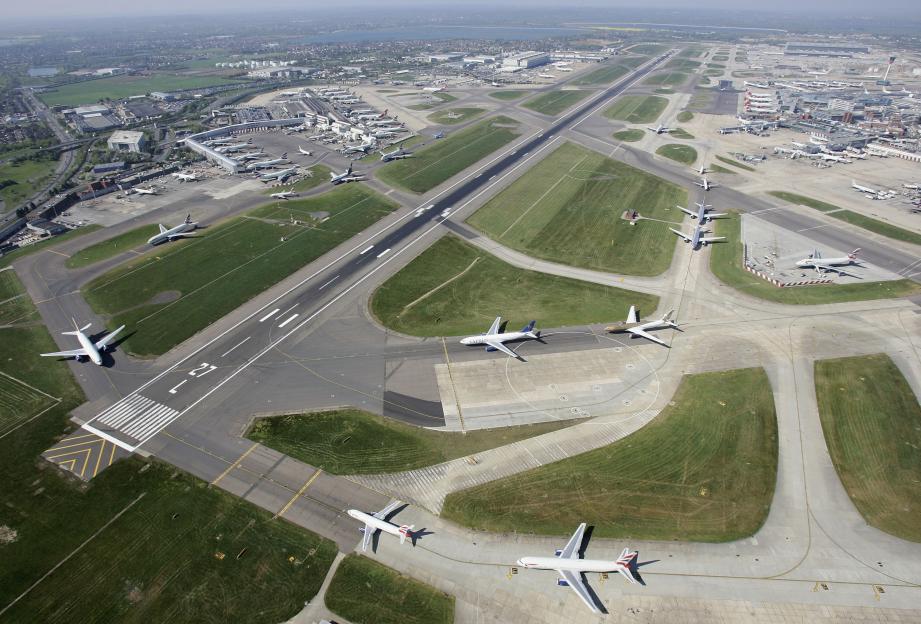 Aerial view of Heathrow Airport showing multiple airplanes on the tarmac and taxiways.