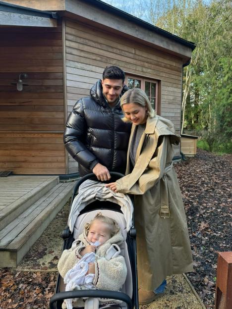 Molly Mae, Tommy, and Bambi standing next to a wooden house and trees.