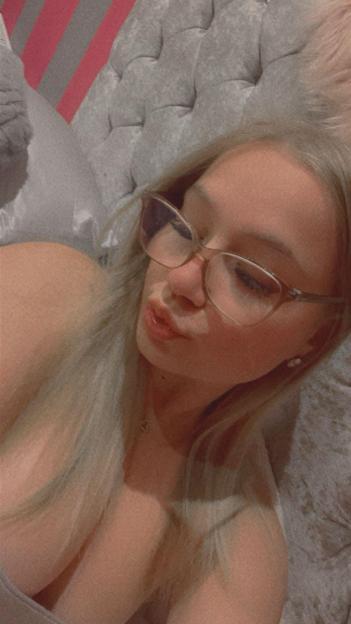 Larisa Sumovskaja in glasses, pouting, with a tufted headboard behind her.