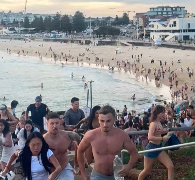 Beach-goers fleeing Bondi Beach after gunmen opened fire.