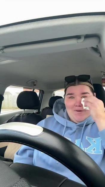 Becki Jones wiping away a tear while sitting in her car.