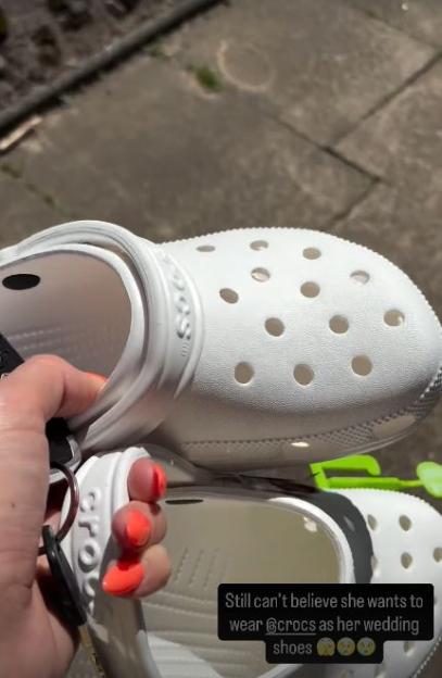 A person holding a pair of white Crocs with the text "Still can't believe she wants to wear @crocs as her wedding shoes" overlaying the image.