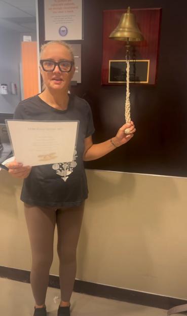 Lucy Davis, star of The Office, rings a bell to celebrate completing cancer treatment.