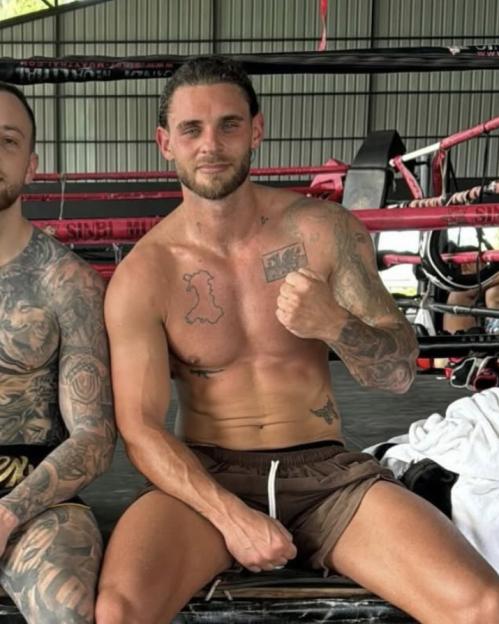 Grant Gale in a Muay Thai gym, showing a Welsh flag motif and AK-47 tattoo.