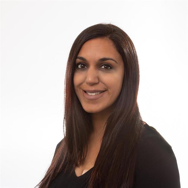 Headshot of a smiling woman with dark hair and dark eyes.