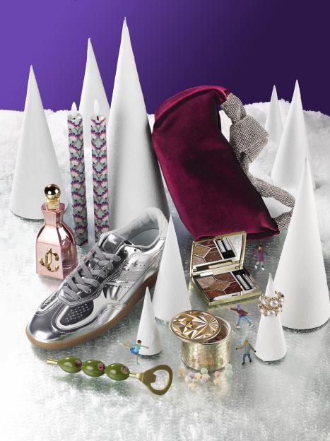 A silver sneaker, pink perfume bottle, two patterned candles, a red velvet bag, an eyeshadow palette, a pearl ring, a decorative box, a bottle opener with olive decorations, and miniature figures of ice skaters on a shimmering surface with white conical decorations, all set against a purple background.
