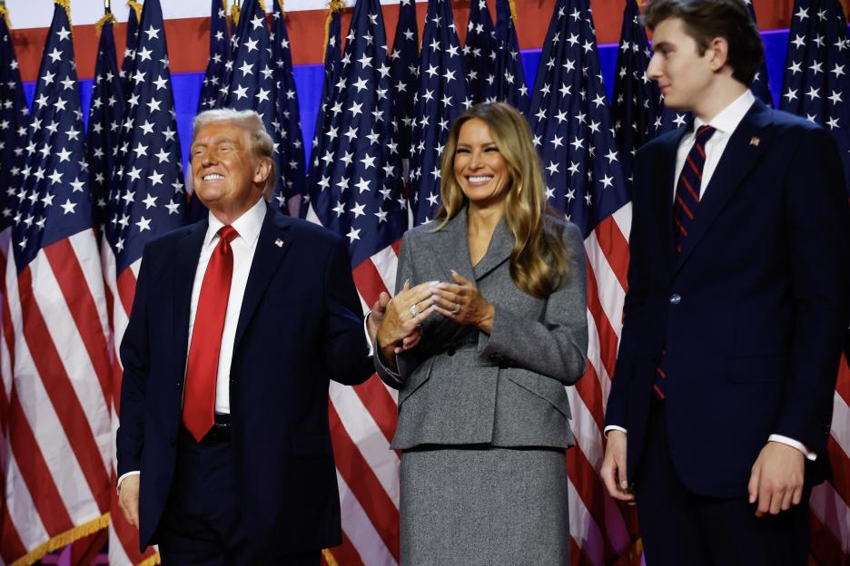 Donald Trump, Melania Trump, and Barron Trump react on stage during an election night event.