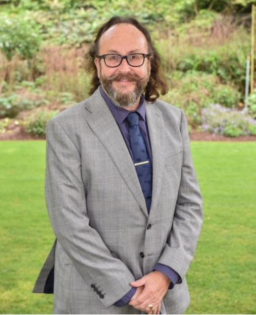 Dave Myers, wearing a gray suit and glasses, smiling for a photo outdoors.
