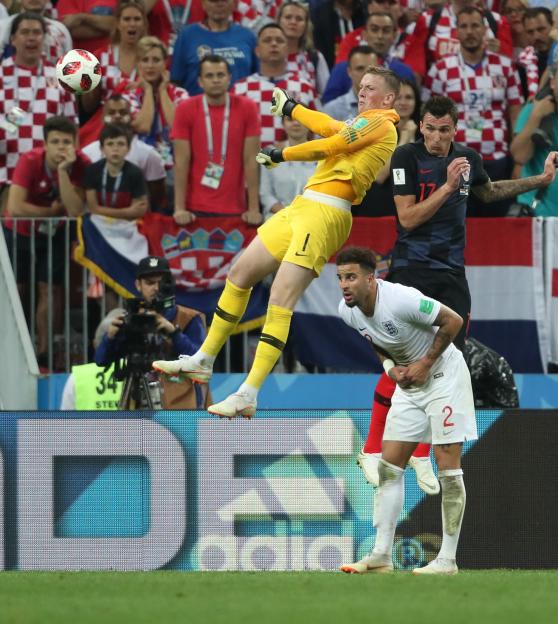 Jordan Pickford of England, Mario Mandzukic of Croatia, and Kyle Walker of England during a FIFA World Cup match.