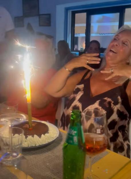 Kim Benstock celebrates her 69th birthday with a sparkler candle in her chocolate cake.